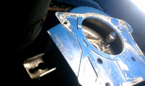 1990 Ford Mustang - Close-up of a blue metal component with visible bolts and a pipe, showing some wear.