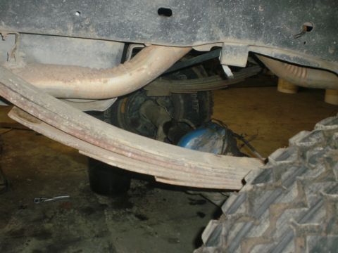 1995 Ford Bronco - Underside view of a vehicle's rear axle and suspension components, with exhaust pipe visible.