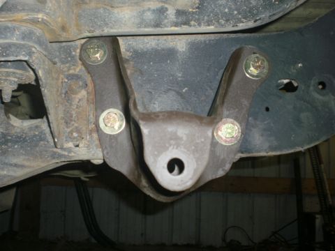 1995 Ford Bronco - A close-up view of a vehicle's rear axle suspension bracket, showing signs of rust and modification.