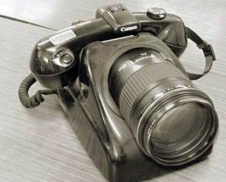 1991 Ford LTD Crown Victoria - A close-up view of a Canon camera with a substantial lens attached, resting on a surface.