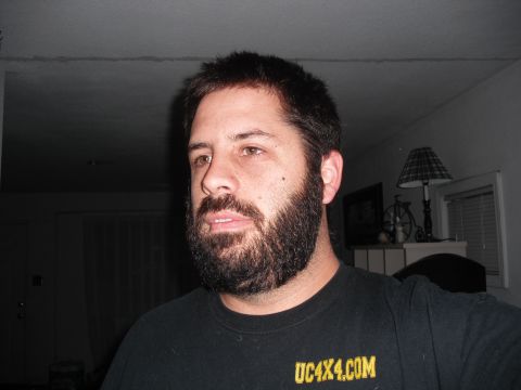 1991 Ford Bronco - A man with a full beard looks to the side while wearing a black t-shirt.