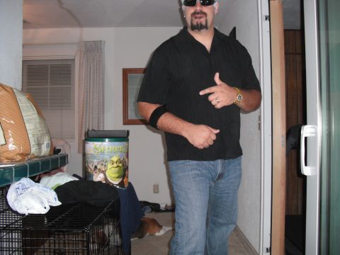 1991 Ford Bronco - A man stands indoors, pointing and wearing casual clothing, with a Shrek-themed trash can visible in the background.
