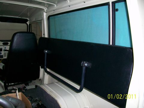 1986 Jeep Wagoneer - Interior view of a vehicle with black seats and a removable panel.