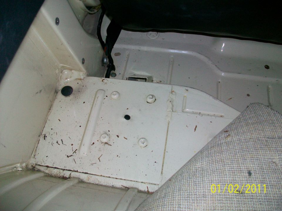 Bare white-painted vehicle floor pan with fabricated tunnel cover panel and wiring lead