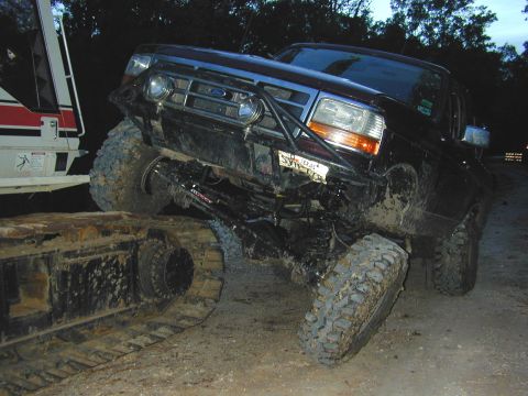 1996 Ford Bronco - A modified Ford Bronco is high-centered on the tracks of an excavator.