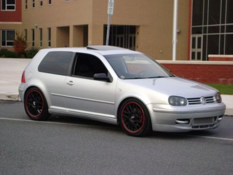 1993 Ford Probe - Silver Volkswagen Golf GTI with custom wheels and red trim is parked in front of a brick building.