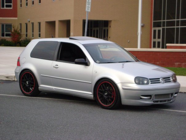 Silver Volkswagen Golf GTI with black BBS wheels and red trim, parked on asphalt