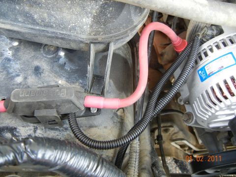 1996 Ford Bronco - Close-up view of vehicle engine bay wiring, including battery cables and alternator connections.