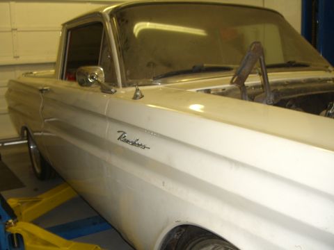 1964 Ford Ranchero - Side view of a 1964 Ford Ranchero in a garage, raised on a lift.