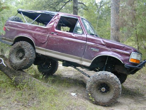 1996 Ford Bronco - This modified 1996 Ford Bronco is navigating an obstacle on an off-road trail.