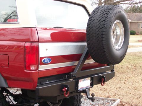 1990 Ford Bronco - Rear view of a red 1990 Ford Bronco, showing its spare tire carrier and custom bumper.