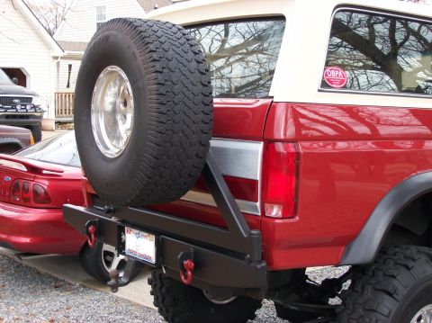 1990 Ford Bronco - This red SUV features a custom rear bumper with a spare tire carrier and tow hitch.