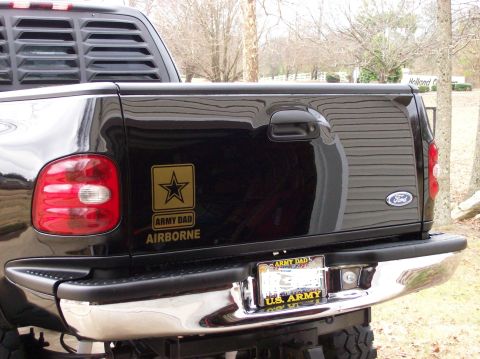 2000 Ford F-150 - Rear view of a black Ford F-150 pickup truck, an 'Army Dad Airborne' sticker and a Ford badge on the tailgate.