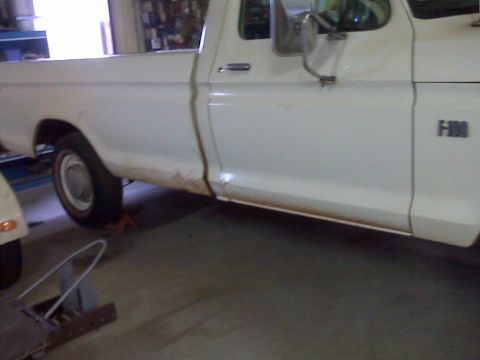 1973 Ford F-100 - This 1973 Ford F-100 pickup truck is shown from the side, revealing some rust along the lower body panels.