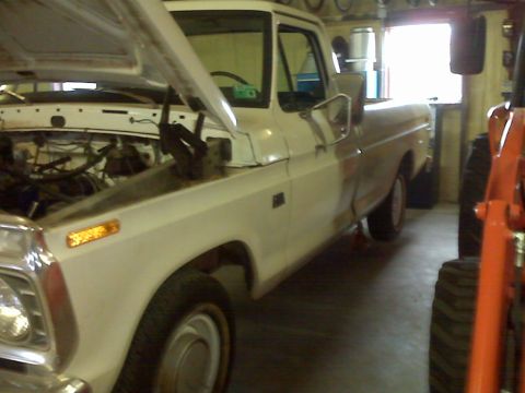 1973 Ford F-100 - This 1973 Ford F-100 pickup truck is parked inside a garage with its hood raised.