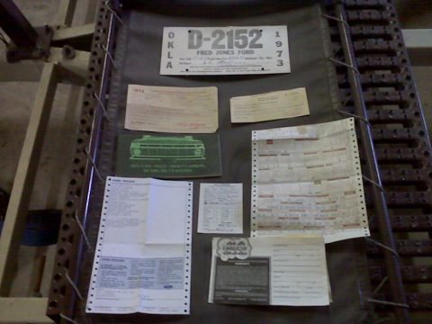1973 Ford F-100 - A collection of vehicle-related documents, including a license plate and sales paperwork.