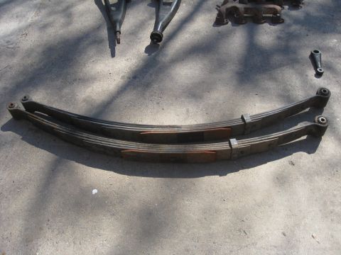 1994 Ford Bronco - Leaf springs and other suspension parts are shown on a concrete surface.