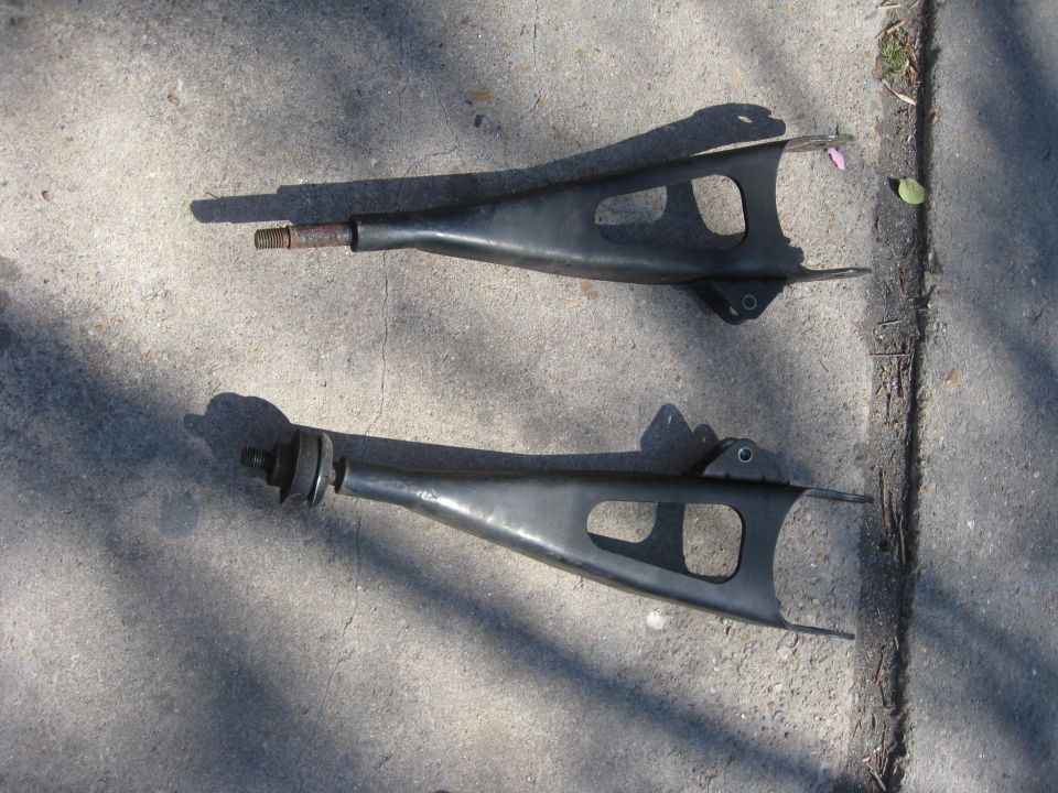 two black control arms on concrete