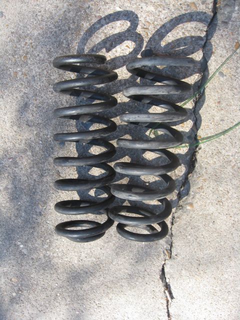 1994 Ford Bronco - A pair of black coil springs are shown on a concrete surface.