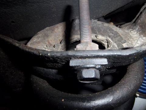 1995 Ford Bronco - This image shows a close-up of a vehicle's suspension system, focusing on a metal component and a bolt.