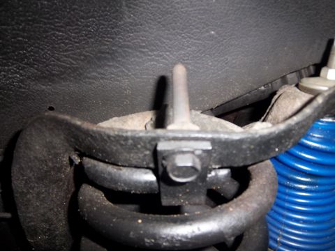 1995 Ford Bronco - A close-up view of a vehicle's suspension system, showing a coil spring and mounting hardware.