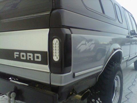 1994 Ford F-150 - Rear view of a Ford pickup truck with a camper shell, showing the tailgate and side panel details.