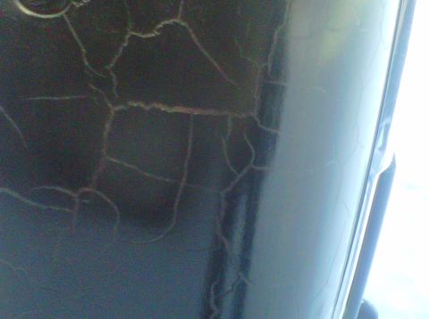 1994 Ford F-150 - The paint on this vehicle panel is severely cracked, showing underlying layers.