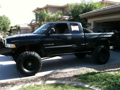 1966 Ford Bronco - Modified black Dodge Ram 2500 V8 pickup truck with large tires and lifted suspension.