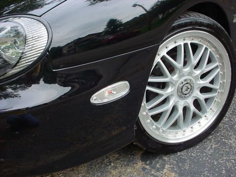 1999 Ford Taurus - Close-up of a car's front corner showing a custom wheel and turn signal light.