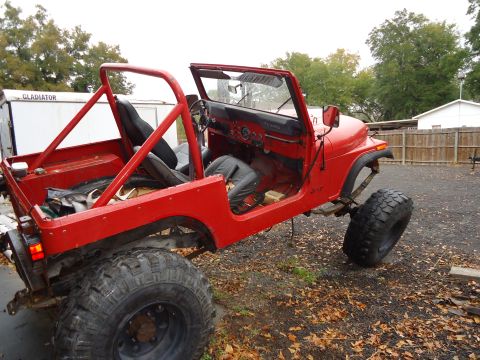 1985 Jeep CJ7 - This 1985 Jeep CJ7 features a roll cage and lifted suspension, ready for off-road adventures.