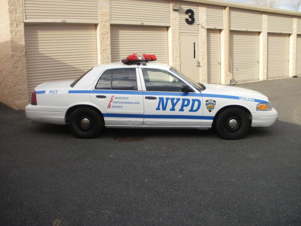 White 2002 Ford Crown Victoria police car with NYPD markings, side view