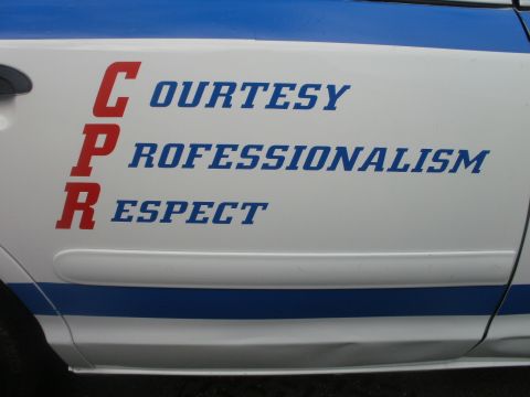 2002 Ford Crown Victoria - Side view of a white vehicle with blue stripes and text spelling out CPR.