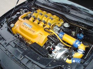1997 Ford Taurus - Close-up view of a V8 engine bay with custom yellow intake components and visible branding.