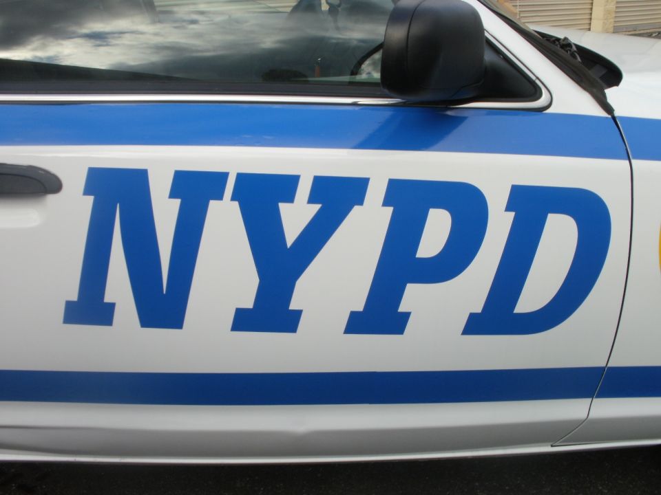 Side view of NYPD car door with blue lettering