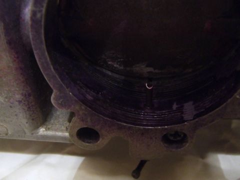 1973 Ford Mustang - Close-up view of the interior of a throttle body, revealing internal grooves and a small metal clip.