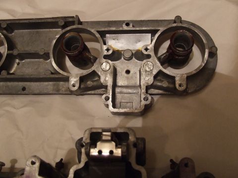 1973 Ford Mustang - This is a close-up view of an automotive intake manifold part, likely made of aluminum, showing internal mechanical components.