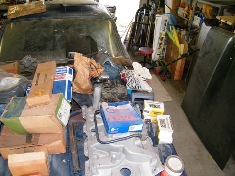1968 Mercury Cougar - The interior of a car is cluttered with various boxes and engine components, obscuring the vehicle's details and year details.