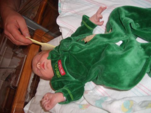 1989 Ford Bronco - A person brushes a baby's hair while the baby lies in a crib wearing a green outfit.