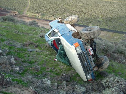 1989 Ford Bronco - This vehicle has rolled off the road and landed on its side.