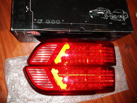 1993 Ford Taurus - Two red LED tail lights, each with yellow tape, are displayed on bubble wrap.