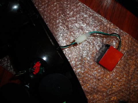 1993 Ford Taurus - A disassembled tail light assembly with its wiring and an attached electronic module is shown.