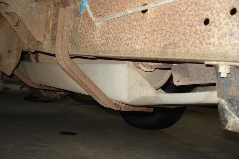 1979 Ford Bronco - The underside of a vehicle reveals a fuel tank and heavily rusted suspension parts, with a Supermotors.net watermark.