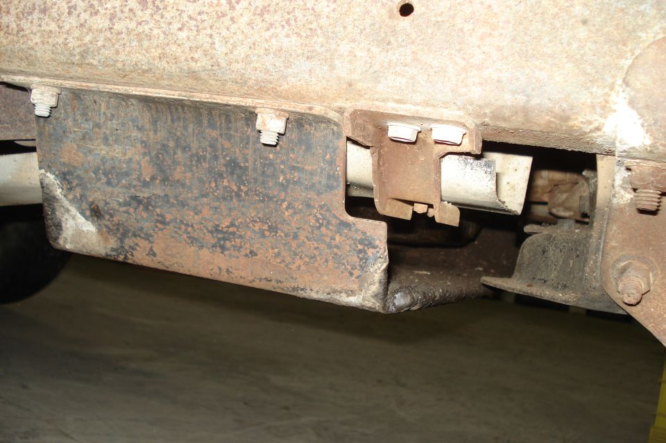 rusted metal bracket attached to vehicle frame with bolts