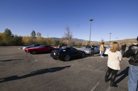 2006 Cadillac STS - Several cars and people are gathered in a parking lot on a sunny day.