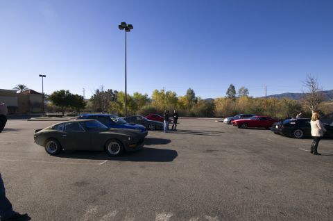 2006 Cadillac STS - A group of cars are gathered in an outdoor parking area under a clear blue sky.