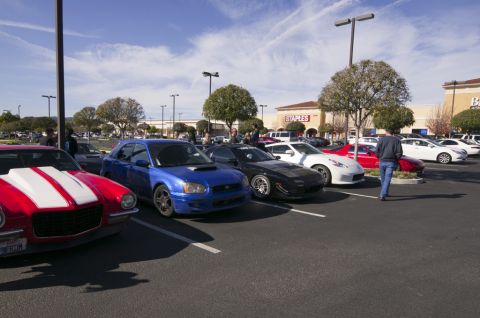 2006 Cadillac STS - A variety of vehicles are parked in a lot on a sunny day, with a Staples store in the background.