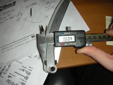 1992 Ford Crown Victoria - A digital caliper is used to measure a component, with various documents visible in the background.