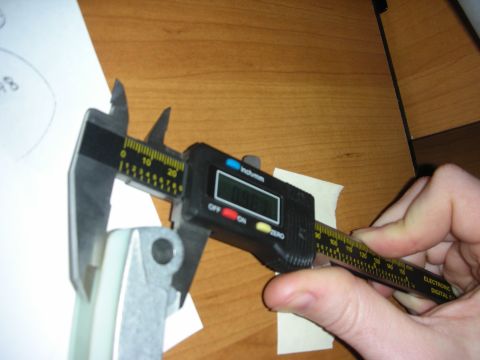 1992 Ford Crown Victoria - A digital caliper is used to measure a mechanical part, with a diagram in the background.
