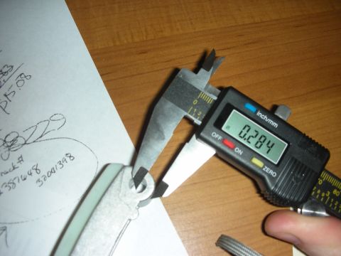 1992 Ford Crown Victoria - A digital caliper measures a metal component, with handwritten notes visible on paper nearby paper nearby paper nearby paper nearby paper n…