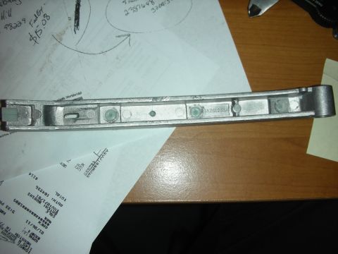 1992 Ford Crown Victoria - A metal part, possibly a component, is shown with visible text and markings on a wooden surface.
